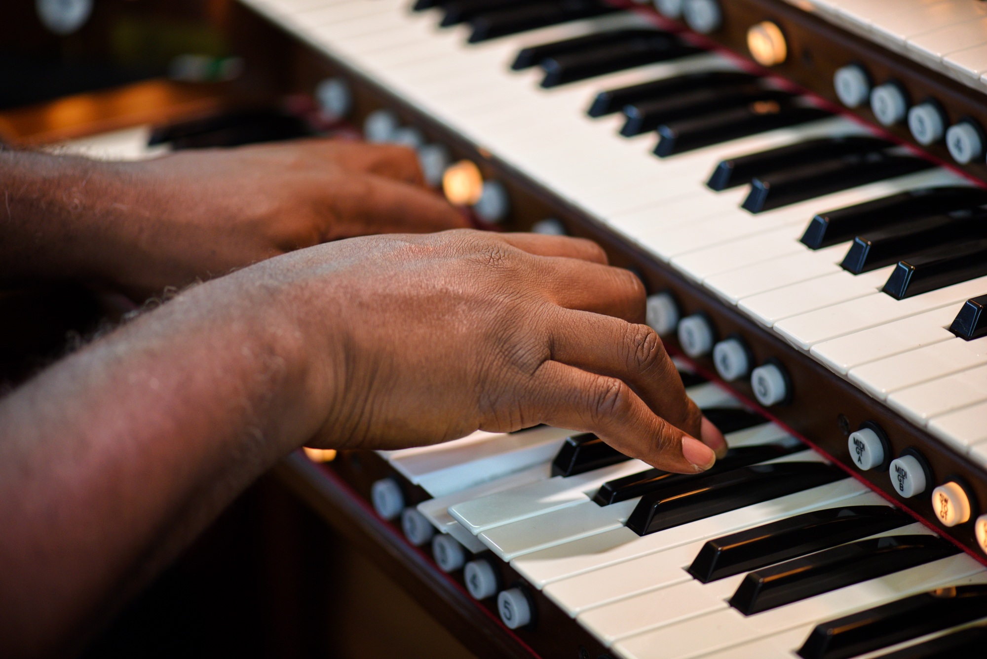 Church musician plays the two keyboard organ during Sunday morning worship